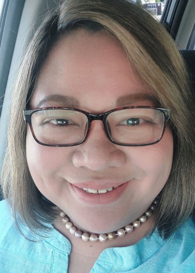 Photo of Anna Mae Angeles co-founder of Home Share for Her wearing glasses and a turquoise blouse